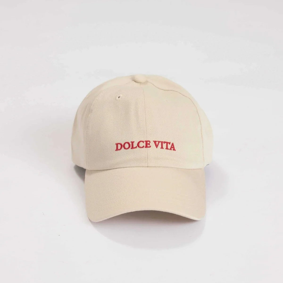Beigefarbene Baseballkappe mit aufgesticktem DOLCE VITA in roten Großbuchstaben auf der Vorderseite, auf weißem Hintergrund.