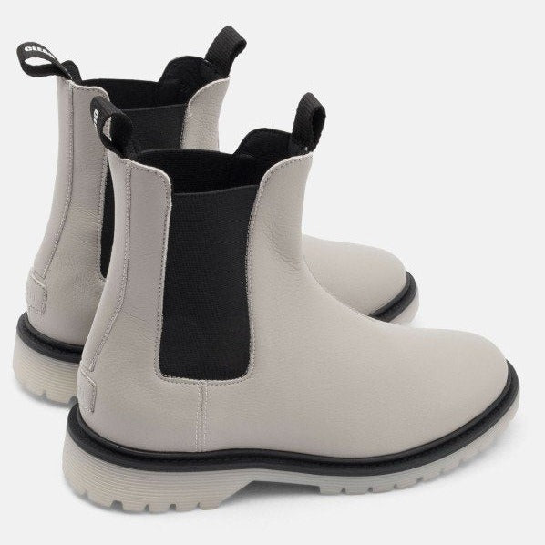Beige Chelsea-Stiefel mit schwarzen elastischen Einsätzen und Laschen an der Rückseite auf weißem Hintergrund.
