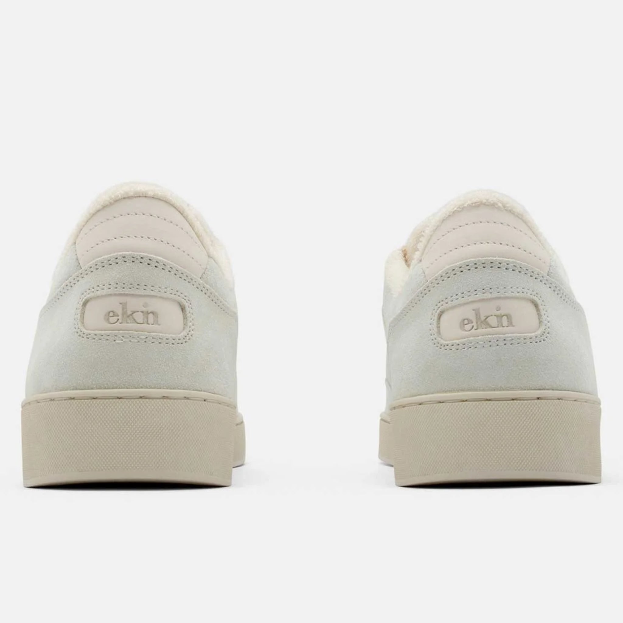 Rückansicht von zwei hellgrauen Sneakers mit beiger Sohle auf weißem Hintergrund.