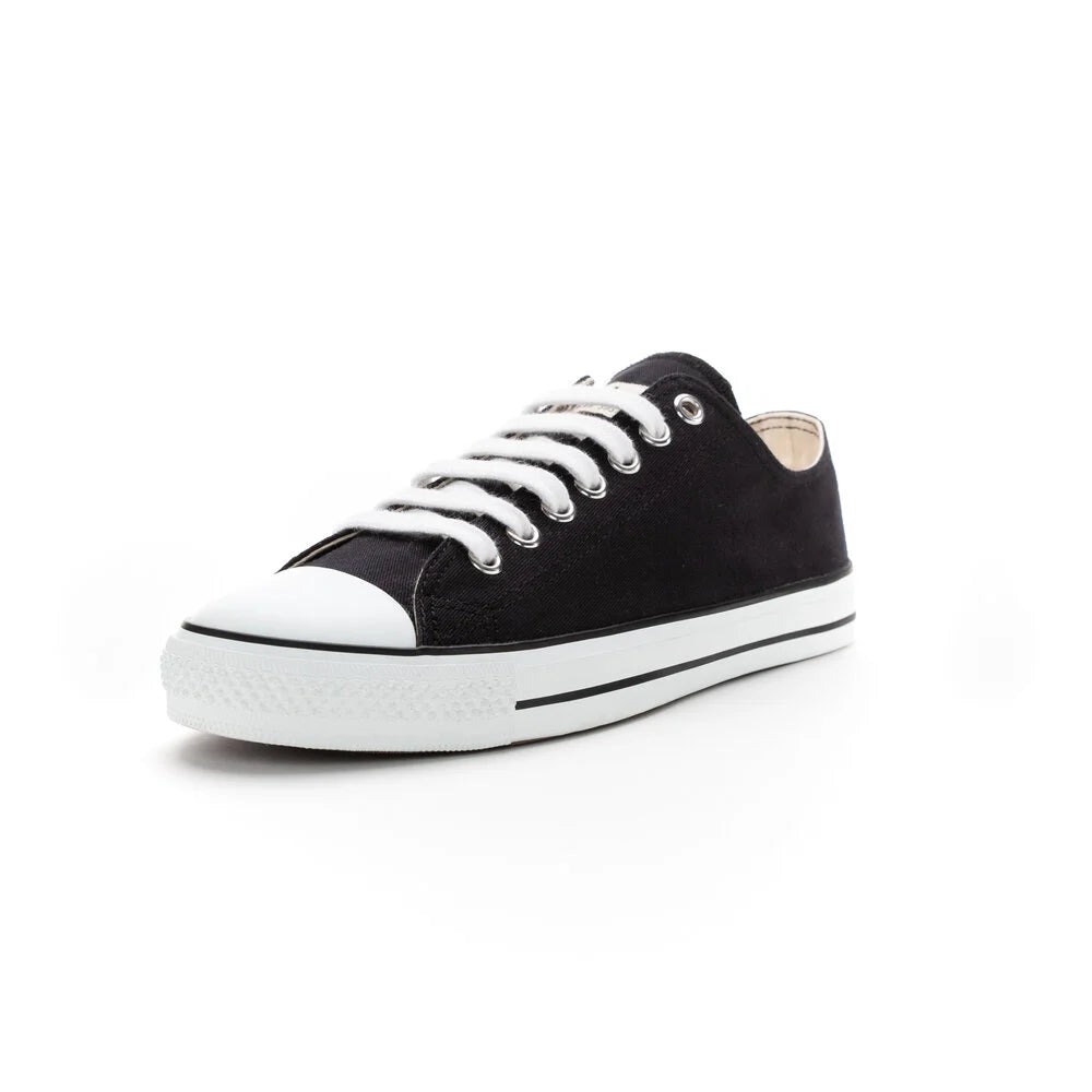 Ein schwarzer Low-Top-Sneaker mit weißen Schnürsenkeln, einer weißen Gummikappe und einer weißen Sohle mit schwarzem Streifen, fotografiert auf weißem Hintergrund.