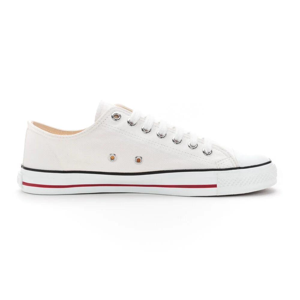 Ein weißer Canvas-Sneaker mit weißen Schnürsenkeln, Metallösen, einer weißen Gummikappe und einer weißen Gummisohle mit schwarzen und roten Streifen. Der Schuh ist von der Seite betrachtet.