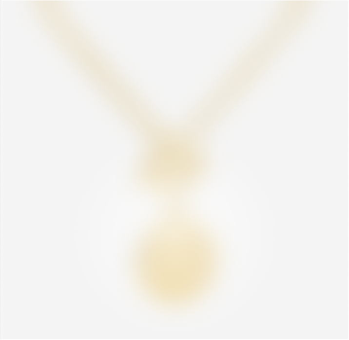 Blurry image of a gold necklace with a round pendant, against a white background.