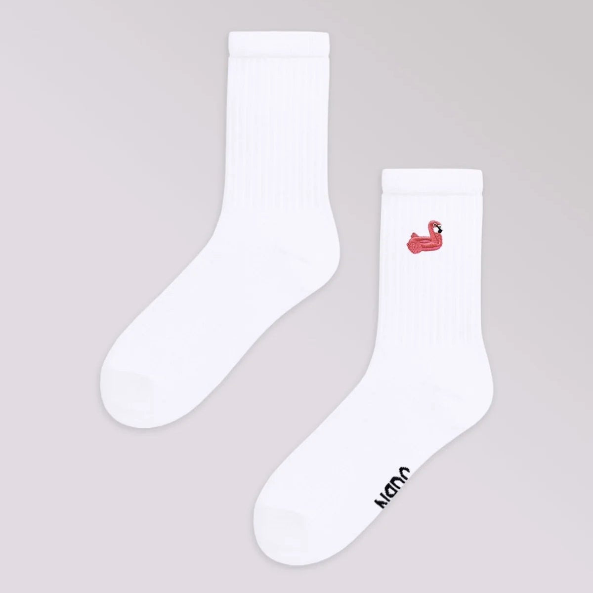 Ein Paar weiße Socken; eine Socke zeigt eine kleine rote Entengrafik im oberen Bereich, die andere hat WON in schwarzer Schrift im Zehenbereich. Die Socken sind flach auf einem hellgrauen Hintergrund gelegt.