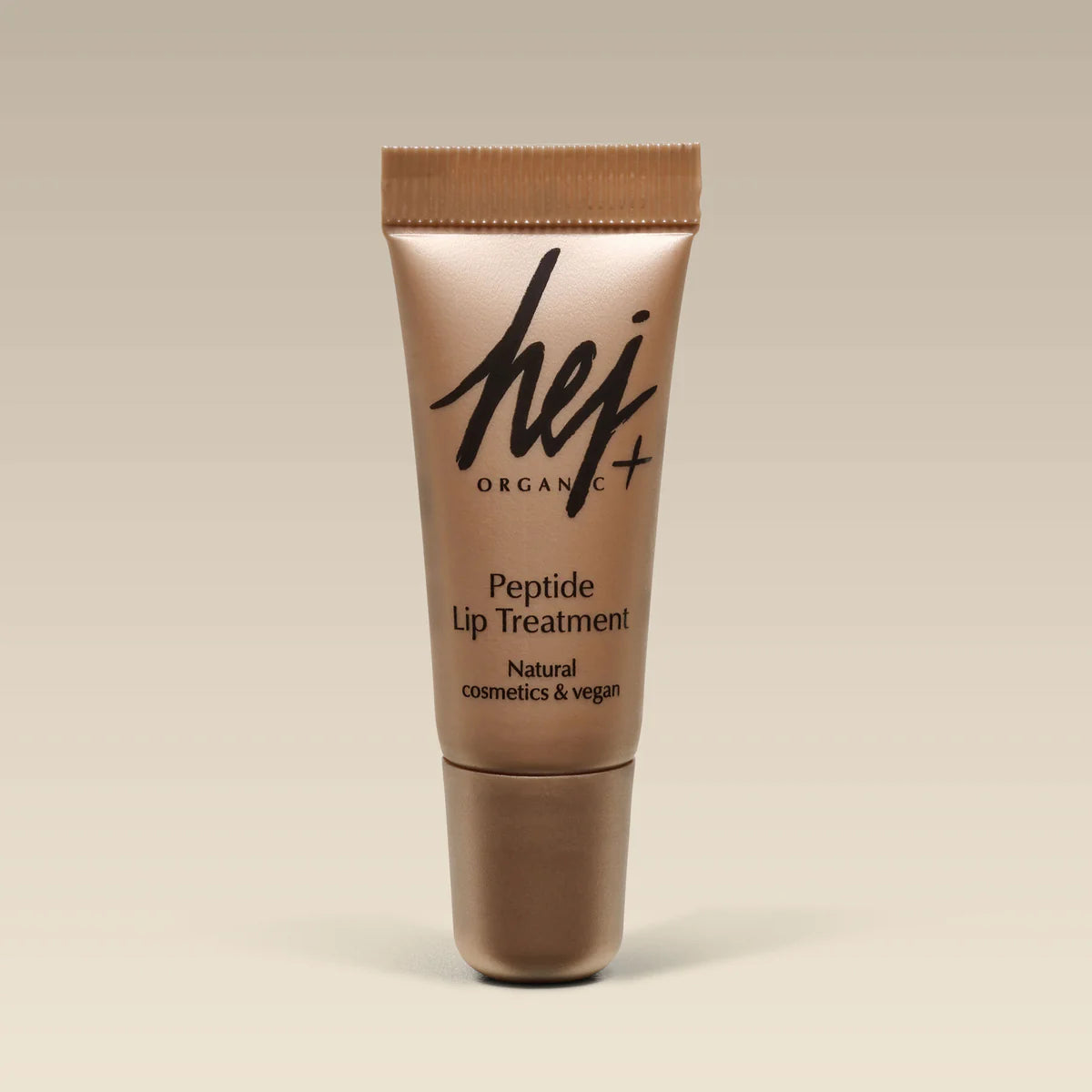 Eine goldene Tube mit der Aufschrift "hej ORGANIC Peptide Lip Treatment - Naturkosmetik & vegan" steht aufrecht vor einem beigen Hintergrund.