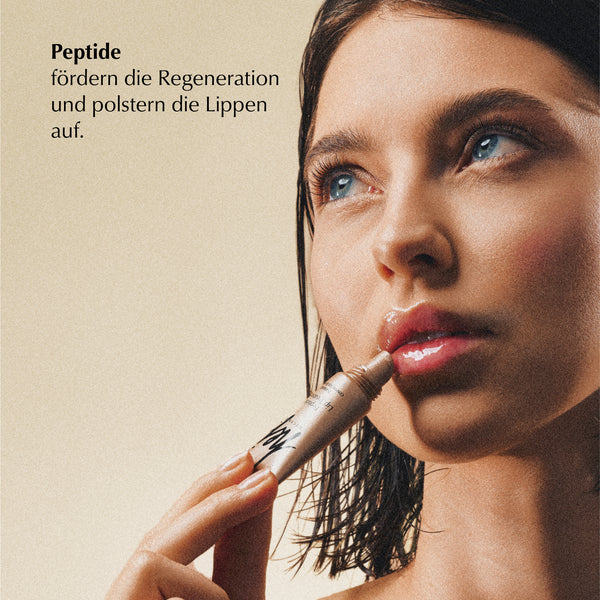 Eine Frau mit nassen Haaren trägt einen Lipgloss oder Balsam auf ihre Lippen auf. Der Text auf Deutsch lautet: Peptide fördern die Regeneration und polstern die Lippen auf, was bedeutet, dass Peptide die Regeneration fördern und die Lippen aufpolstern.