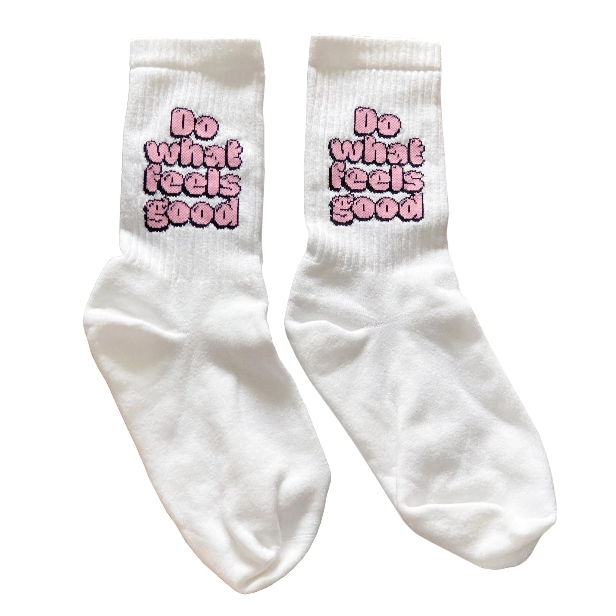 Ein Paar weiße Socken mit der Aufschrift "Do what feels good" (Tu, was sich gut anfühlt) in fetten, rosafarbenen Blasenbuchstaben im Knöchelbereich.