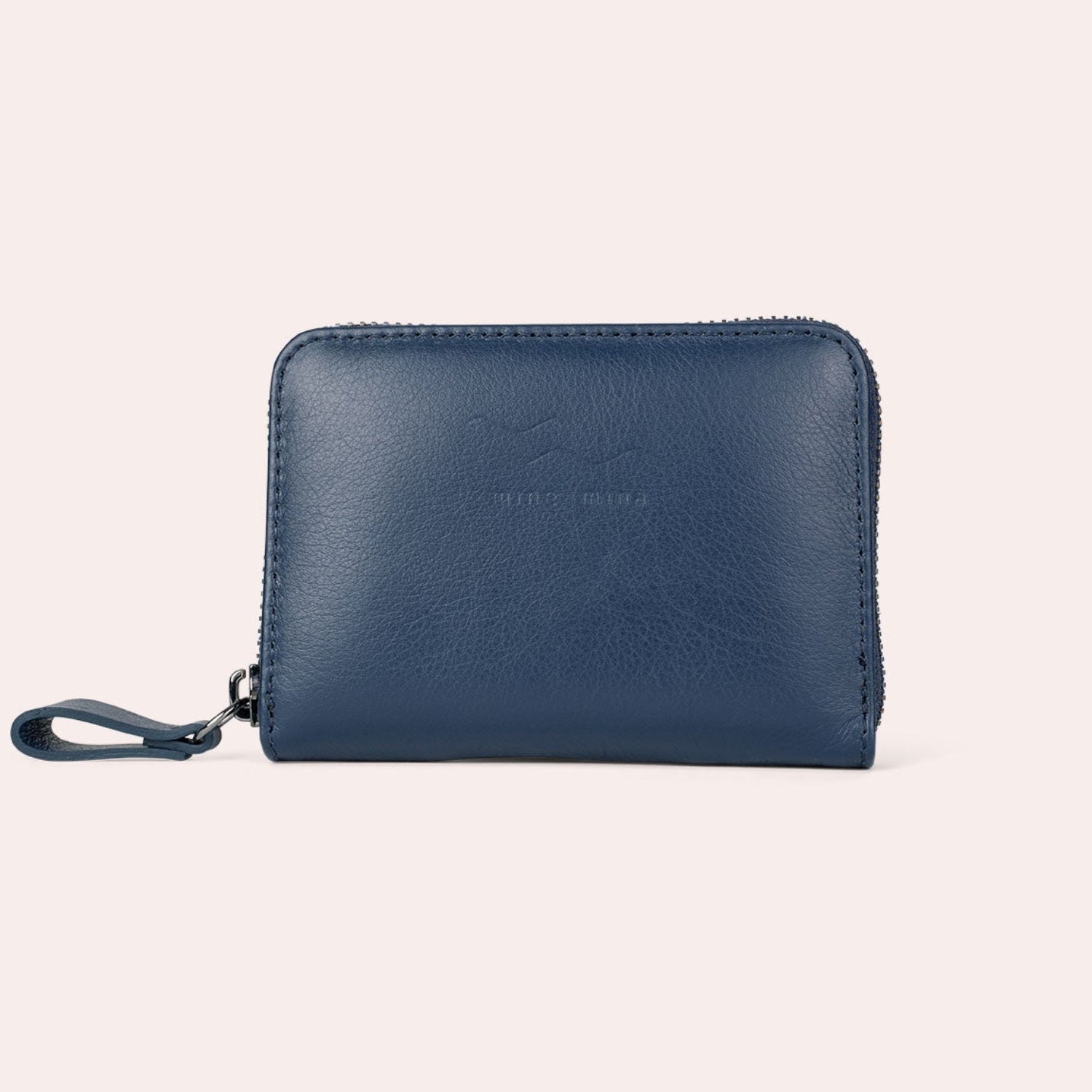 Eine kleine, rechteckige blaue Ledergeldbörse mit Reißverschluss und Handschlaufe, die vor einem schlichten, hellen Hintergrund gezeigt wird.