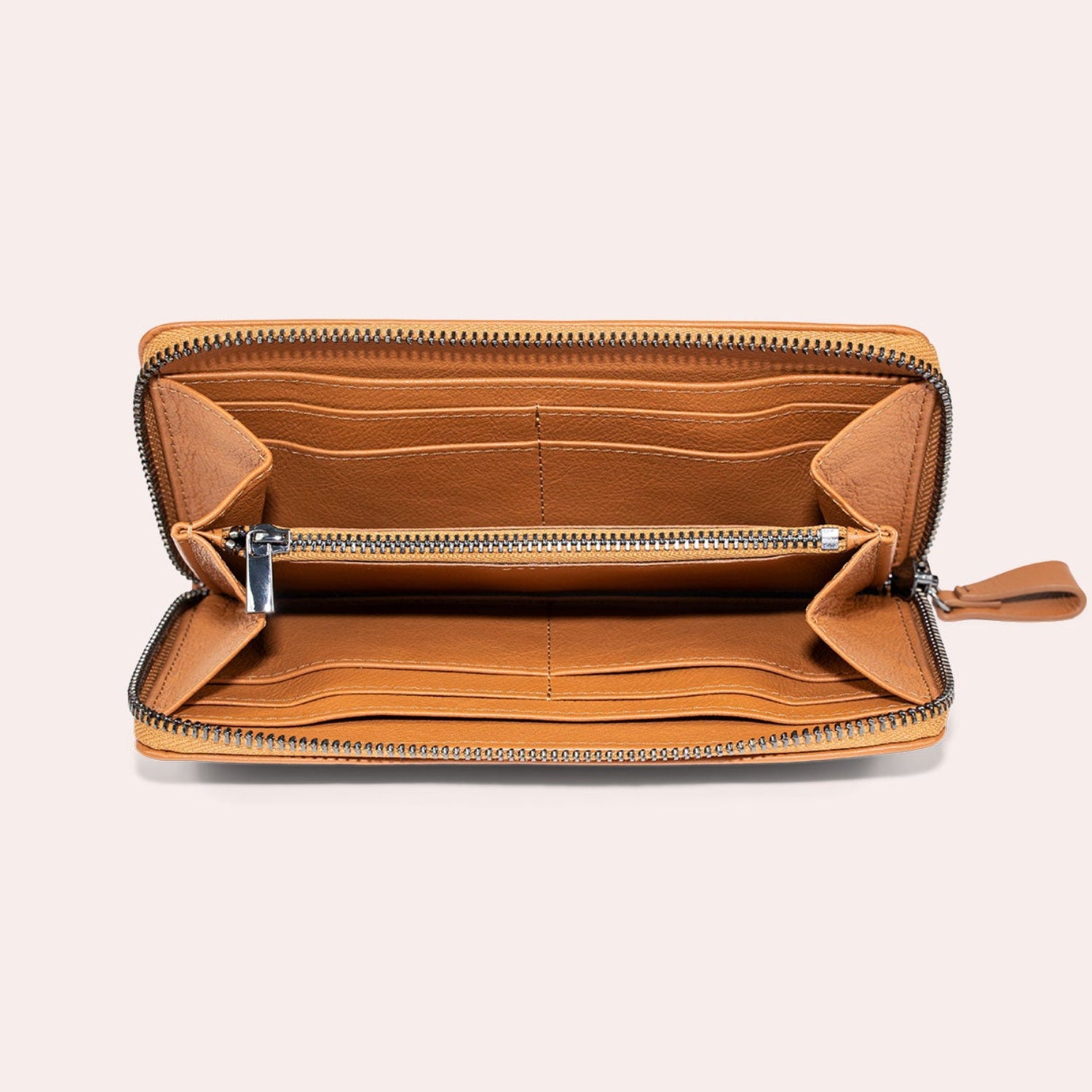 Offene, hellbraune Ledergeldbörse mit Reißverschluss, die mehrere Kartenfächer und ein zentrales Münzfach mit Reißverschluss auf einem hellbeigen Hintergrund aufweist.