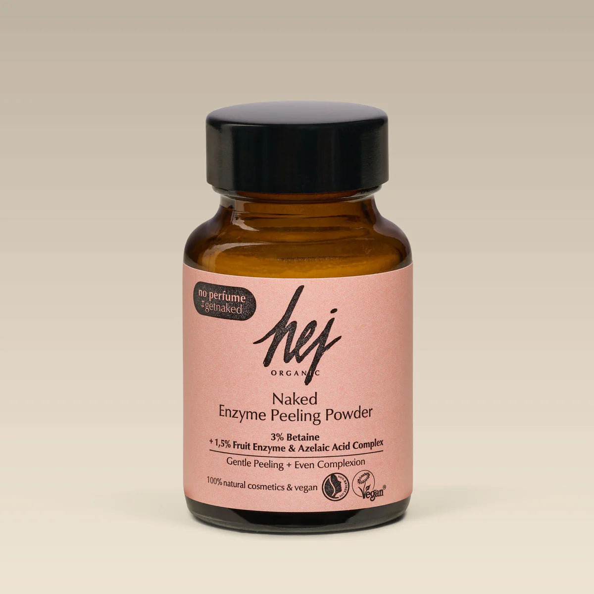 Ein brauner Glastiegel mit schwarzem Deckel mit der Aufschrift hej ORGANIC Naked Enzyme Peeling Powder auf hellbeigem Hintergrund. Auf dem Etikett steht, dass es vegan, sanft und parfümfrei ist.