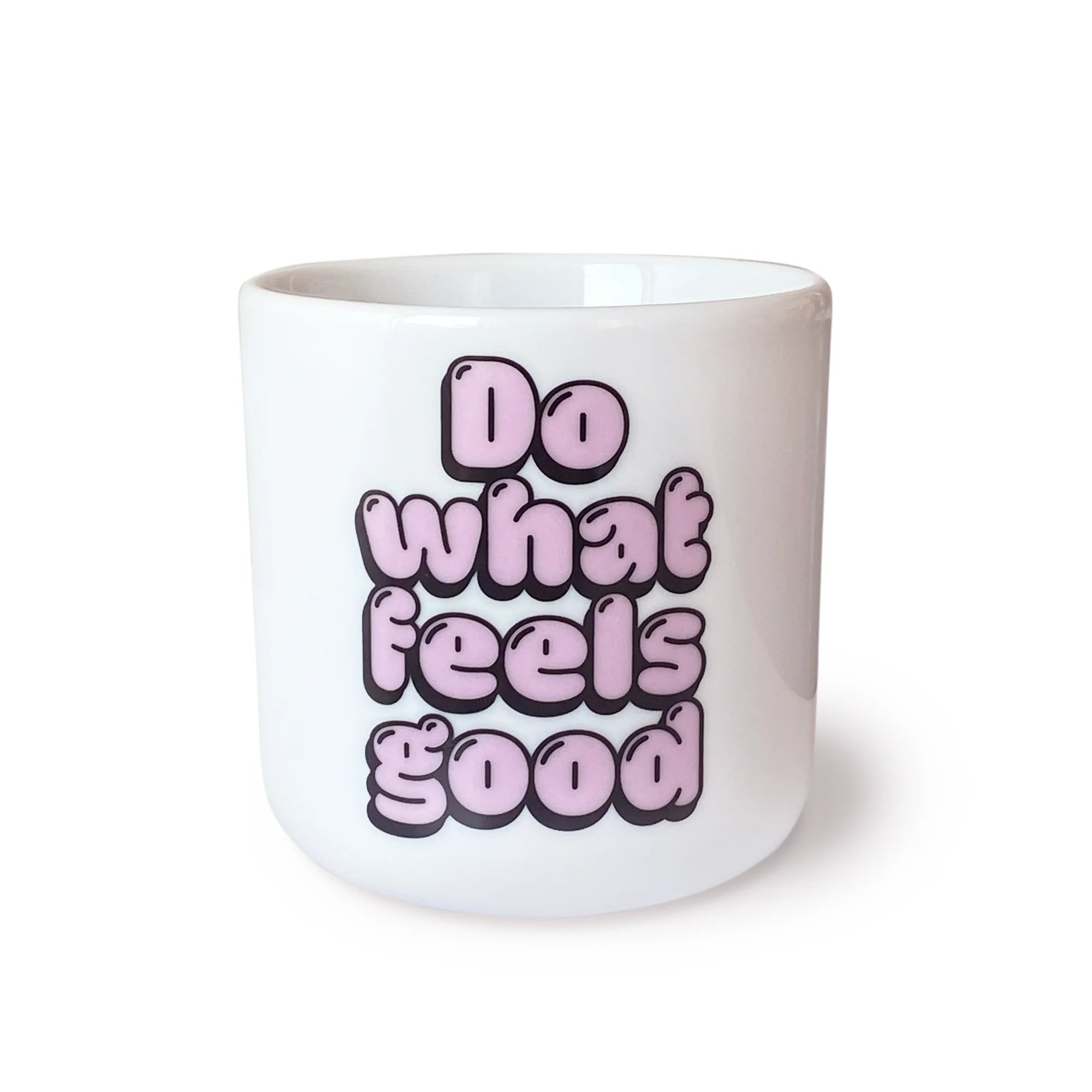 Eine weiße Keramiktasse, auf deren Vorderseite in fetten, rosafarbenen Blasenbuchstaben der Satz "Do what feels good" steht.
