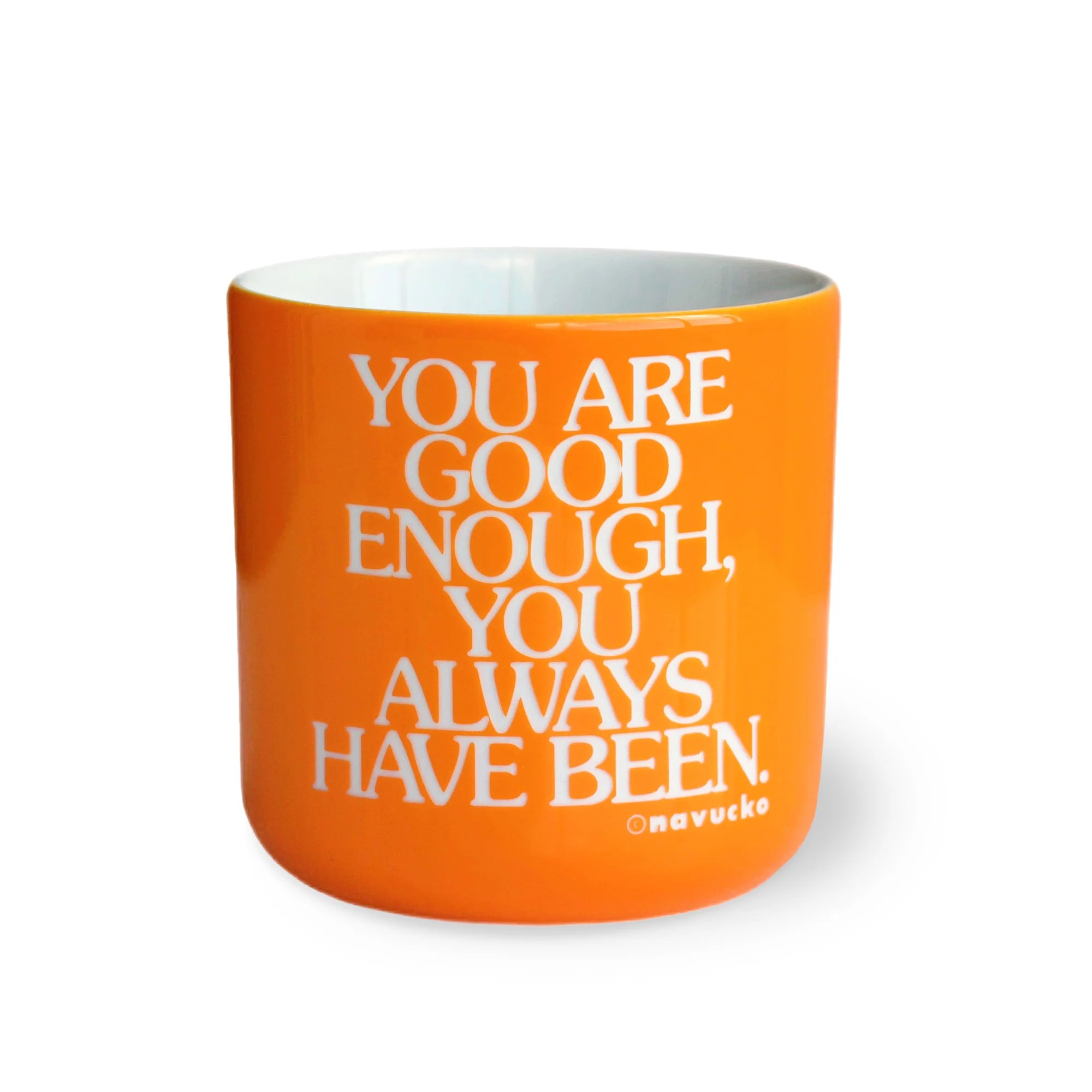 Eine orangefarbene Tasse mit der weißen Aufschrift: DU BIST GUT GENUG, DAS WARST DU SCHON IMMER. Der Name Onavukko steht in kleinen weißen Buchstaben unten rechts.