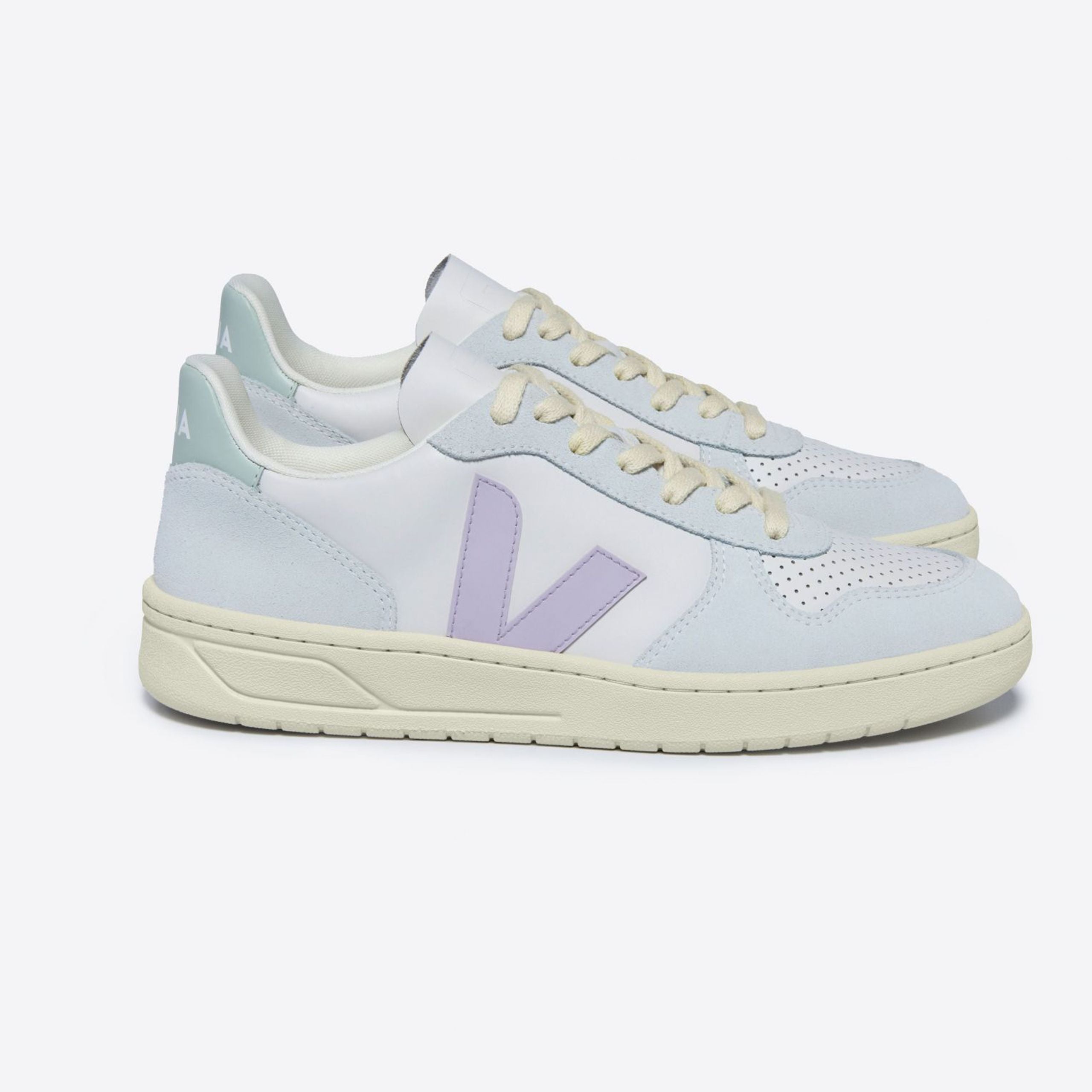 Zwei hellblaue und weiße Turnschuhe mit lila Logo auf weißem Hintergrund.