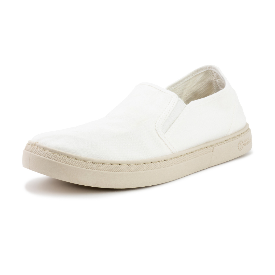 Weißer Slip-On-Schuh mit beigefarbener Sohle und leichter Rundung an der Fußspitze.