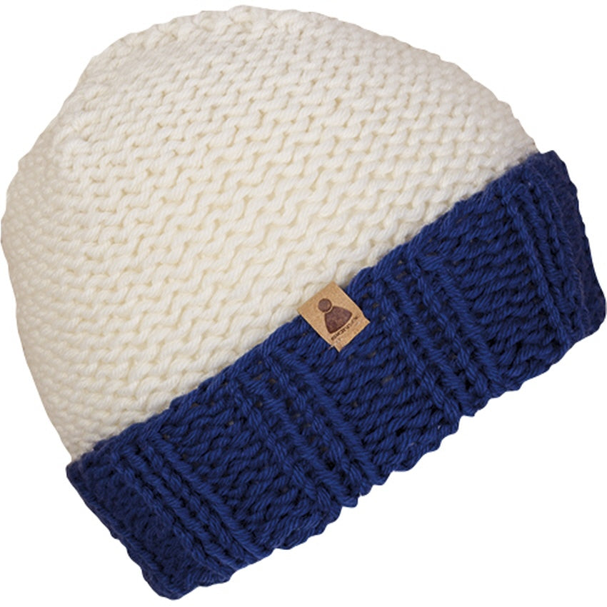 Eine gestrickte Beanie-Mütze mit einem dicken weißen Scheitel und einer dicken blauen gefalteten Krempe mit einem kleinen braunen Anhänger an der Krempe.