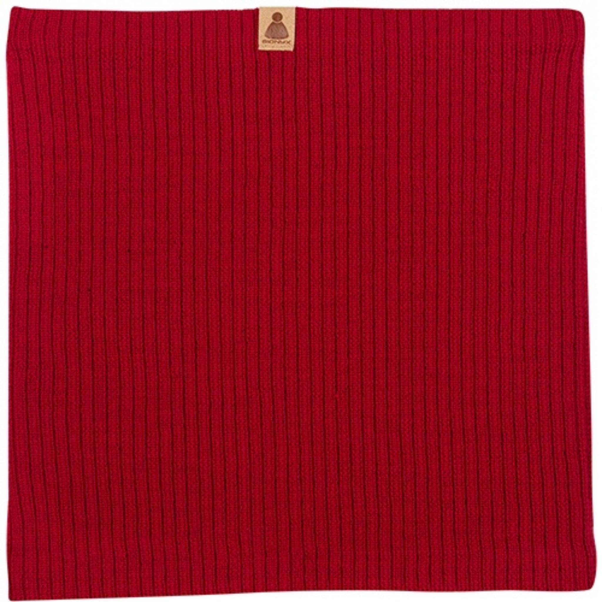 Ein quadratisches, geripptes rotes Strickstück mit einem kleinen braunen rechteckigen Etikett in der oberen Mitte.