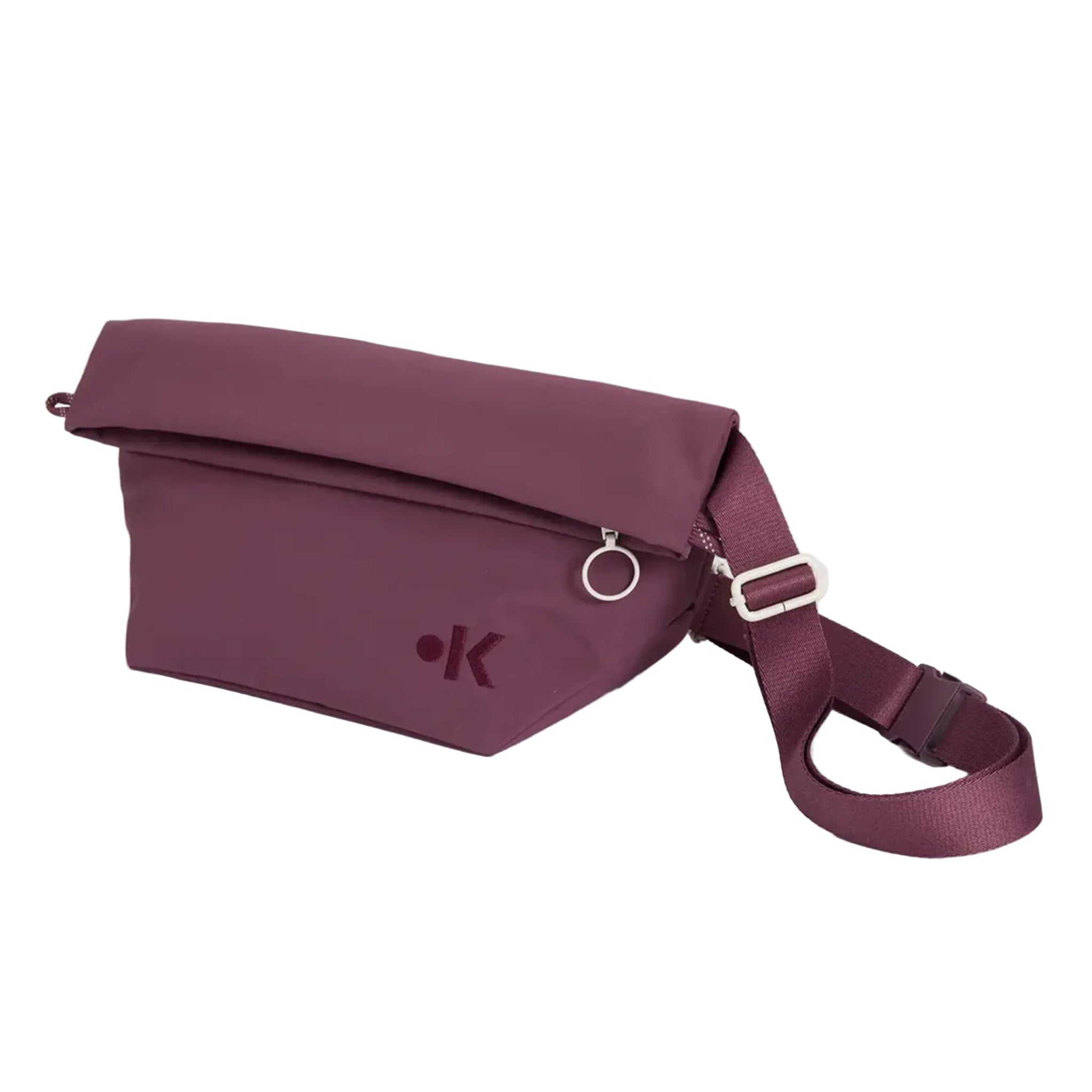 Kastanienbraune Crossbody-Tasche mit umklappbarem Deckel, silbernem Reißverschluss, verstellbarem Riemen und kleinem, kreisförmigem Metallring. Die Tasche hat ein minimalistisches, geprägtes Logo auf der Vorderseite.