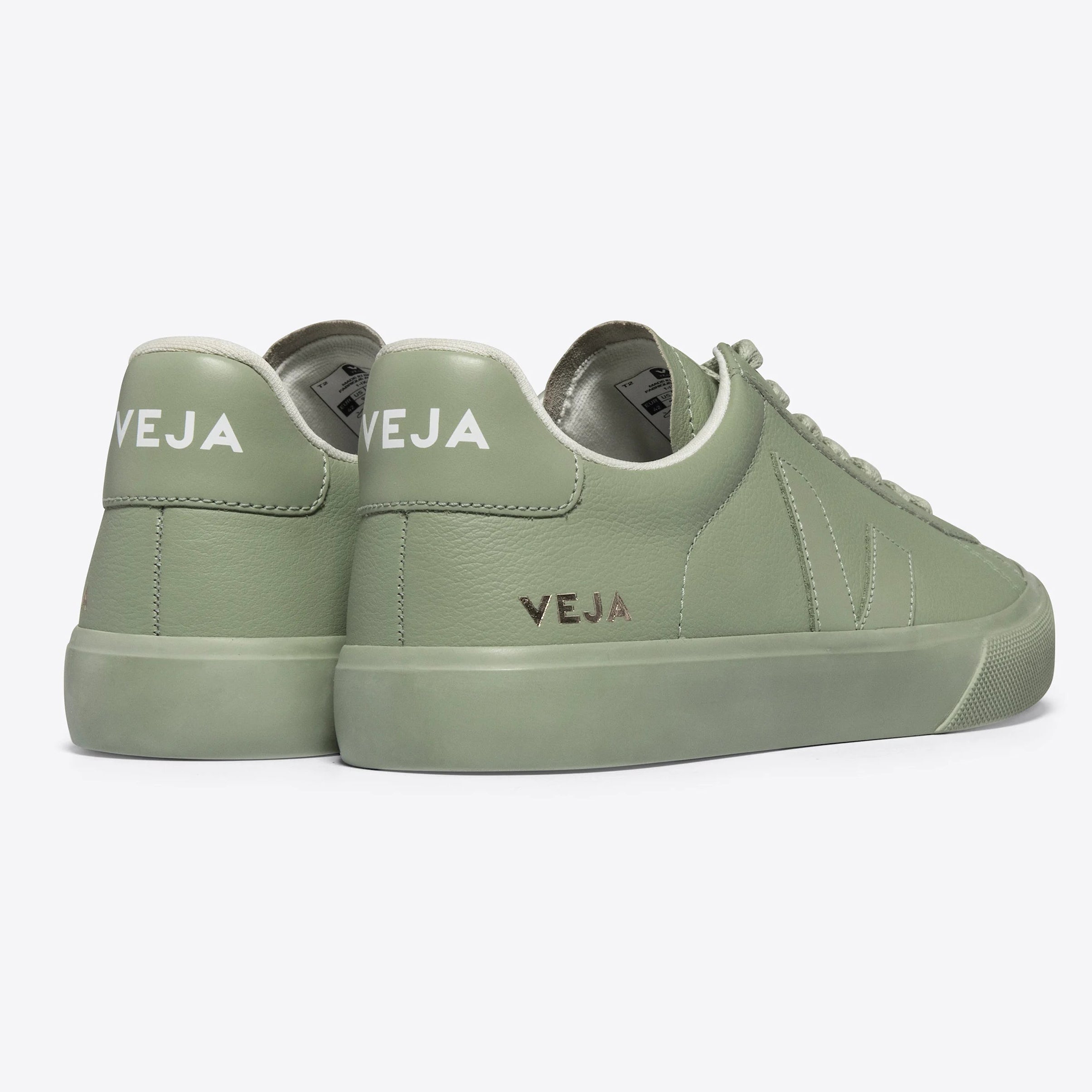 Ein Paar hellgrüne Veja-Sneaker von hinten und von der Seite gesehen, mit weißem VEJA-Branding an der Ferse und minimalistischem Design auf einem schlichten hellen Hintergrund.