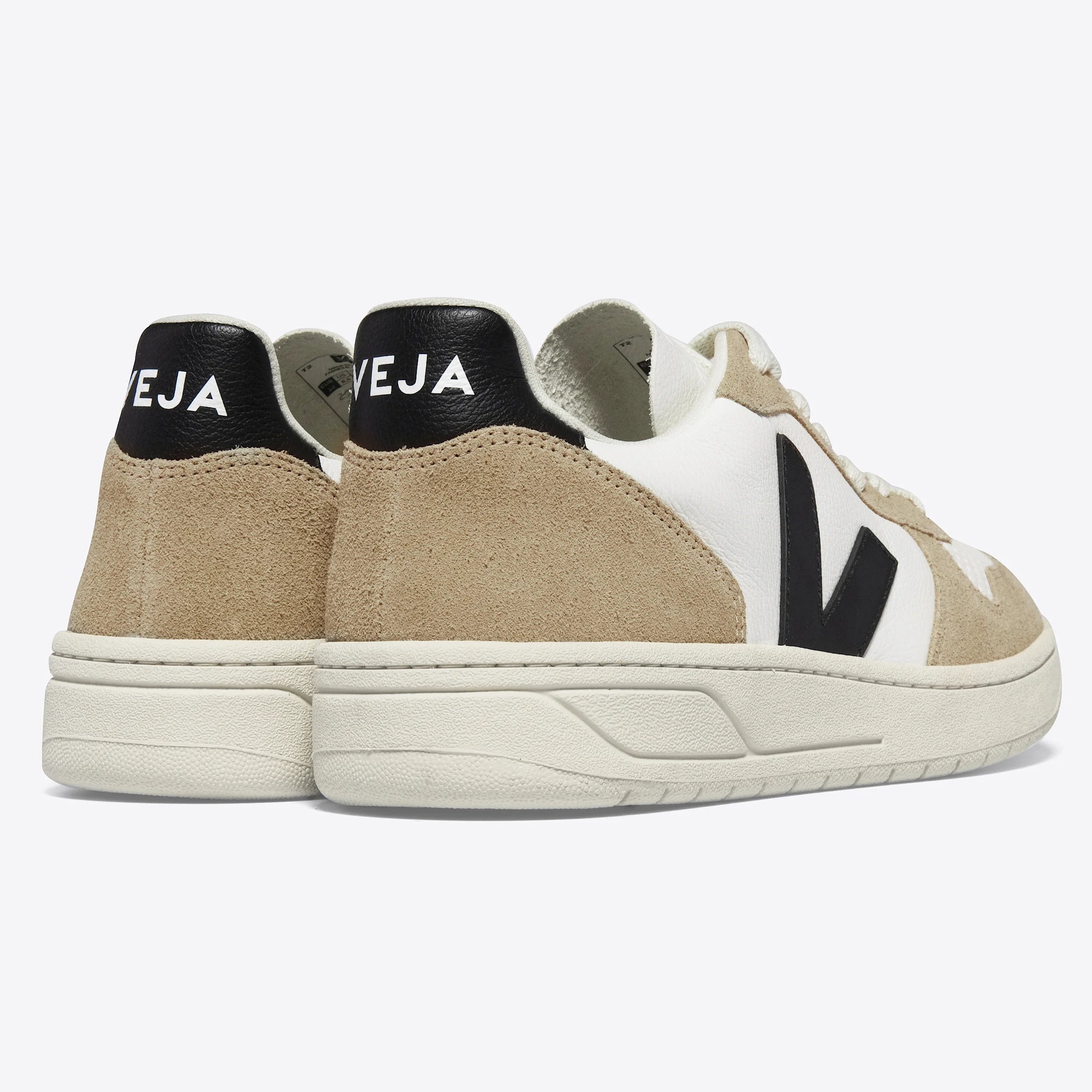 Ein Paar beige-weiße Veja-Sneakers mit schwarzem V-Logo an den Seiten und VEJA-Aufdruck auf den schwarzen Fersenlaschen, die auf einem schlichten weißen Hintergrund zu sehen sind.