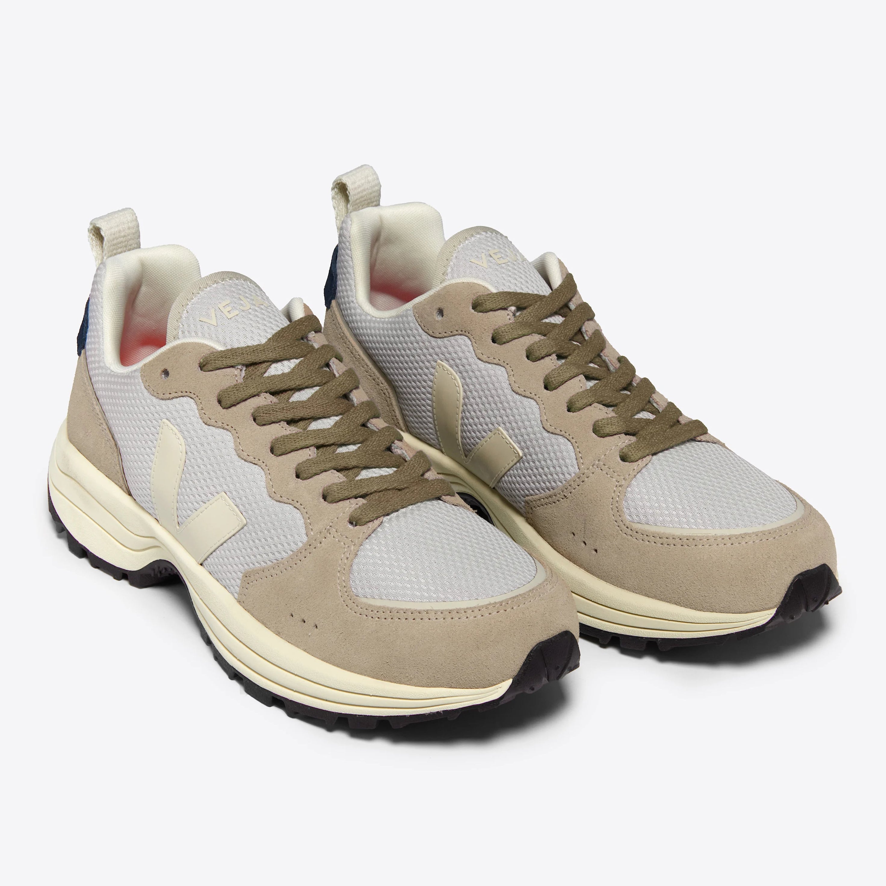 Ein Paar beigefarbene und hellgraue Turnschuhe mit weißer Sohle, olivgrünen Schnürsenkeln und einem cremefarbenen V-Logo an den Seiten, das auf einem einfarbig weißen Hintergrund steht.