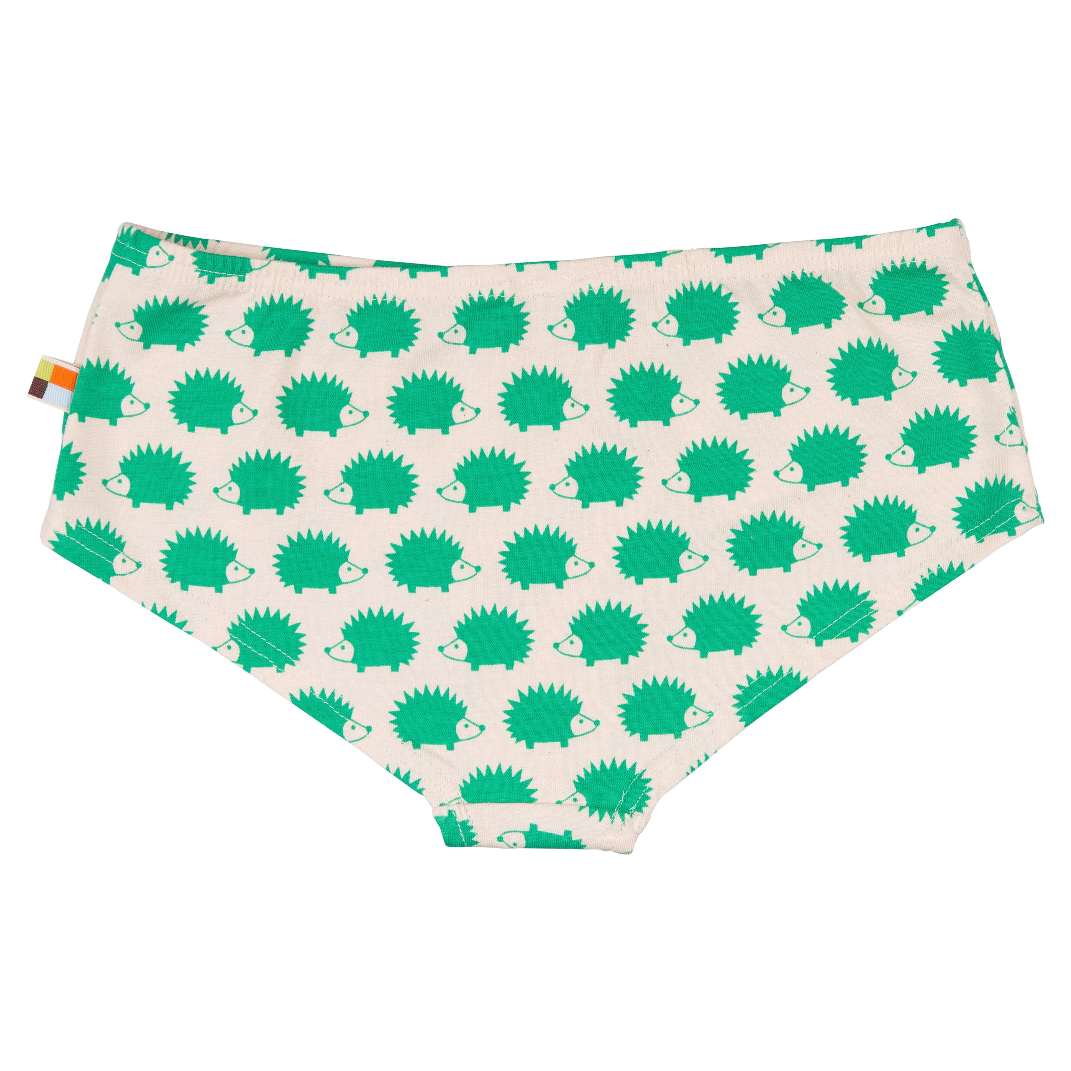 Cremefarbene Unterwäsche mit einem sich wiederholenden grünen Igelmuster und einem kleinen mehrfarbigen Anhänger auf der linken Seite. Das Design ist verspielt und skurril.