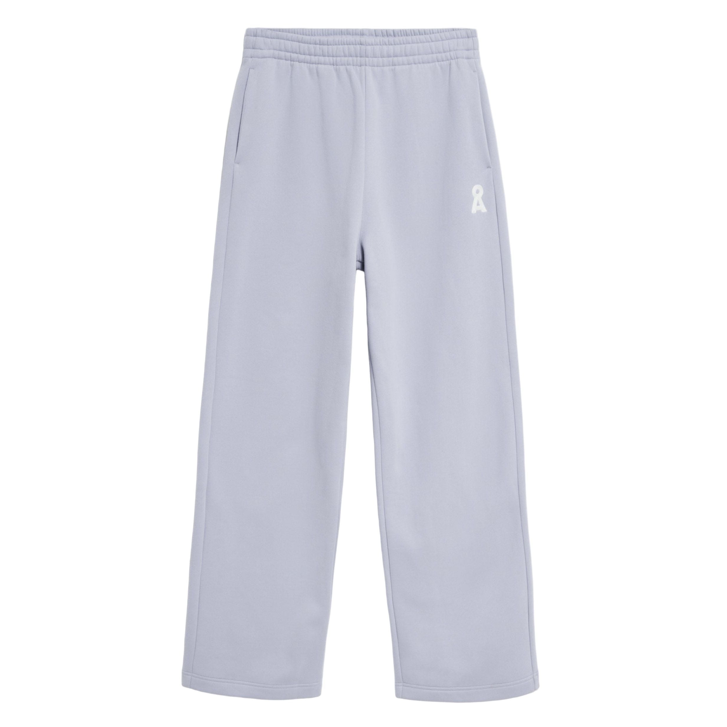 Hellgraue Jogginghose mit elastischem Bund, Seitentaschen und einem kleinen weißen Bandlogo auf dem linken Oberschenkel auf weißem Grund.