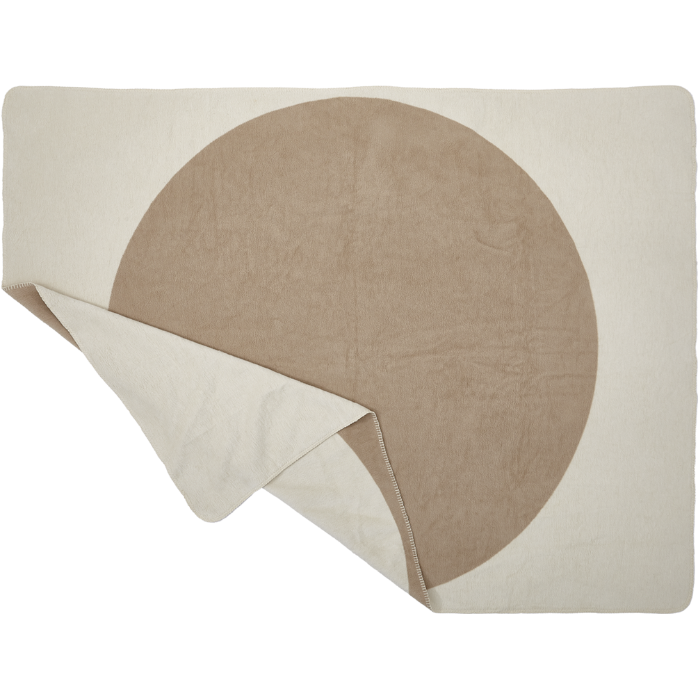 Eine rechteckige beigefarbene Decke mit einem großen hellbraunen Kreis in der Mitte, die an einer Ecke teilweise gefaltet ist, so dass die Unterseite sichtbar wird.