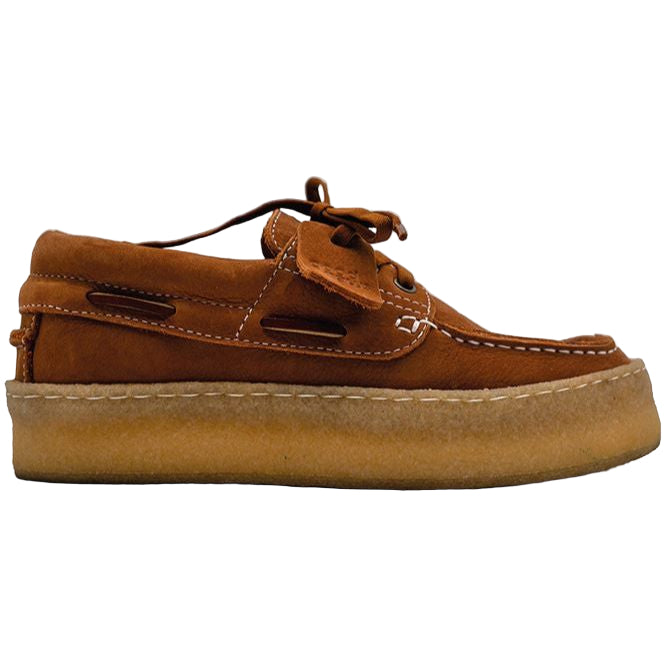 Ein brauner Bootsschuh aus Wildleder mit weißen Nähten, Schnürung und einer dicken, hellbraunen Kreppsohle, dargestellt im Seitenprofil auf einem unifarbenen Hintergrund.