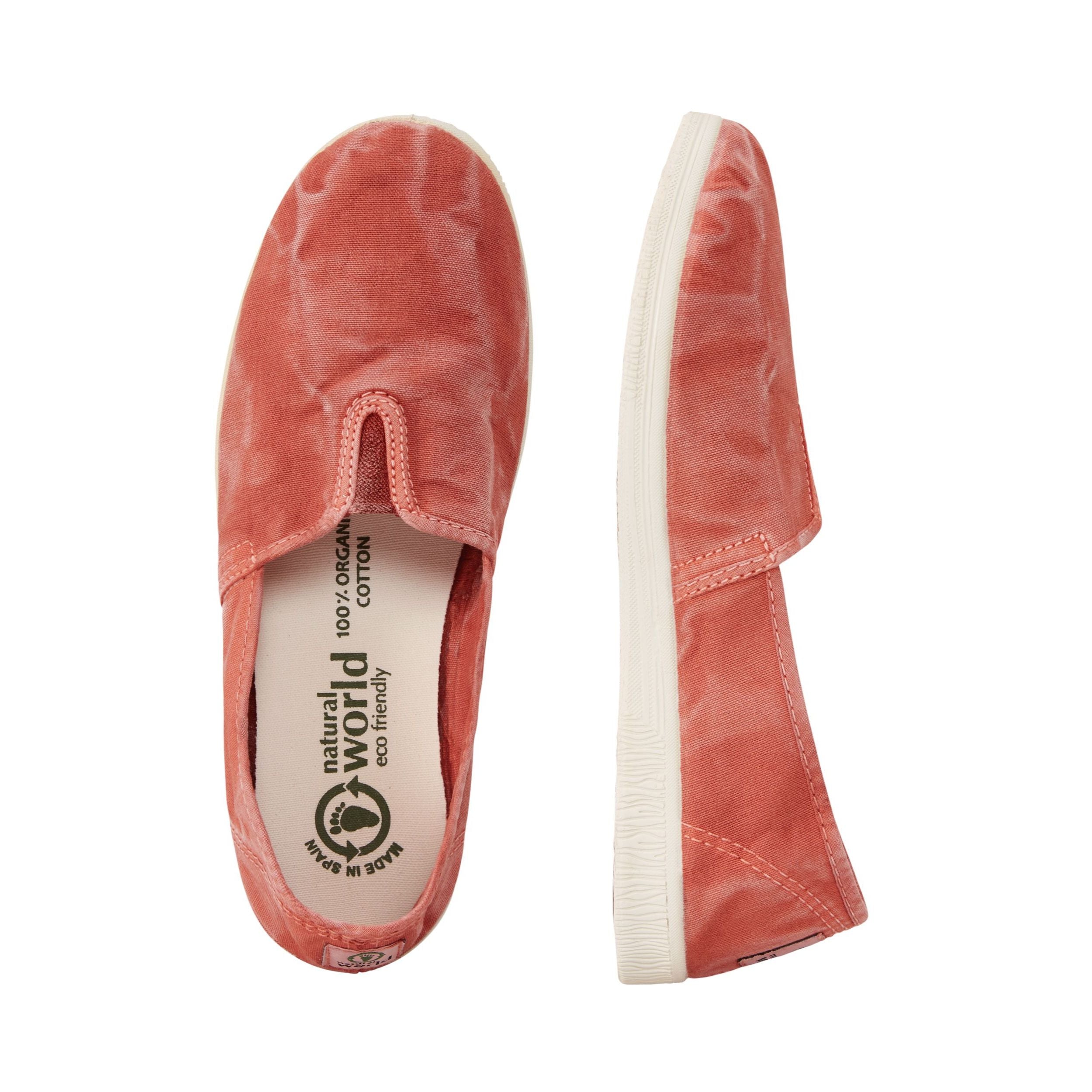 Zwei rosafarbene Stoffschuhe mit weißen Sohlen, einer aus der Vogelperspektive, der andere seitlich gezeigt.