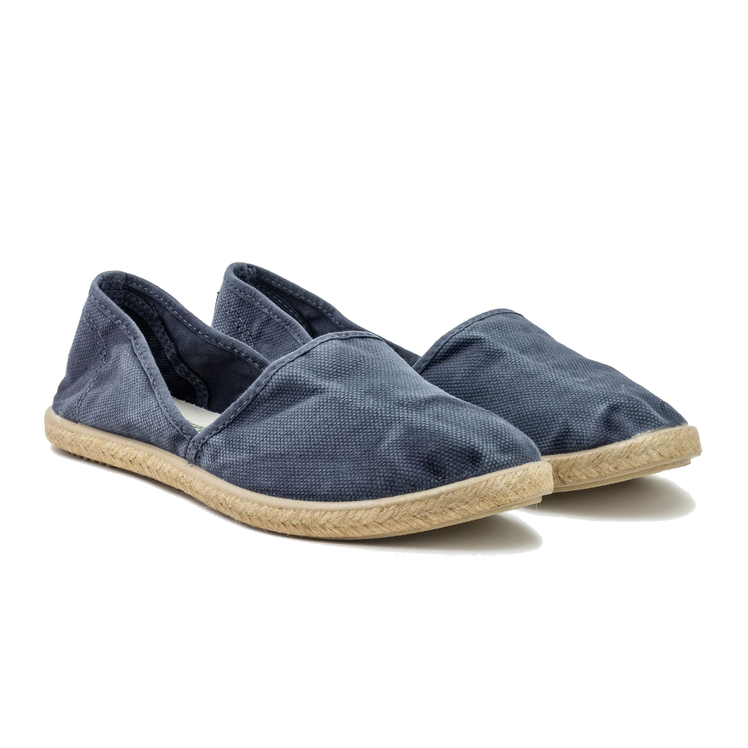 Dunkelblaue Espadrilles aus Stoff mit geflochtener, beigefarbener Bastsohle auf weißem Hintergrund.