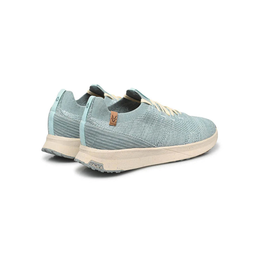 Ein Paar hellblaue, gestrickte Turnschuhe mit weißer Sohle und weißen Schnürsenkeln, dargestellt von hinten auf einem weißen Hintergrund.