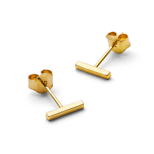 Goldene Ohrstecker in T-Form auf weißem Hintergrund.