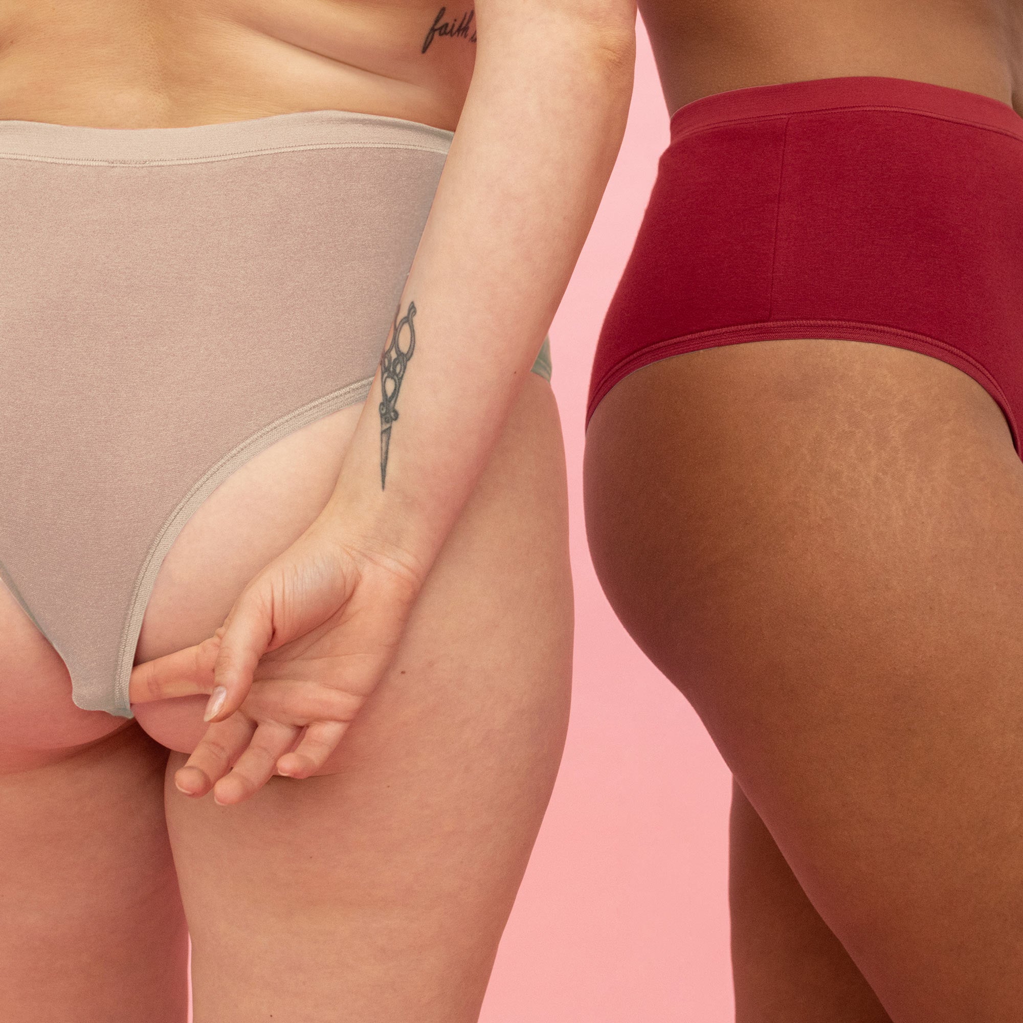 Zwei Personen in Unterwäsche vor rosa Hintergrund, eine mit Tätowierung am Arm.