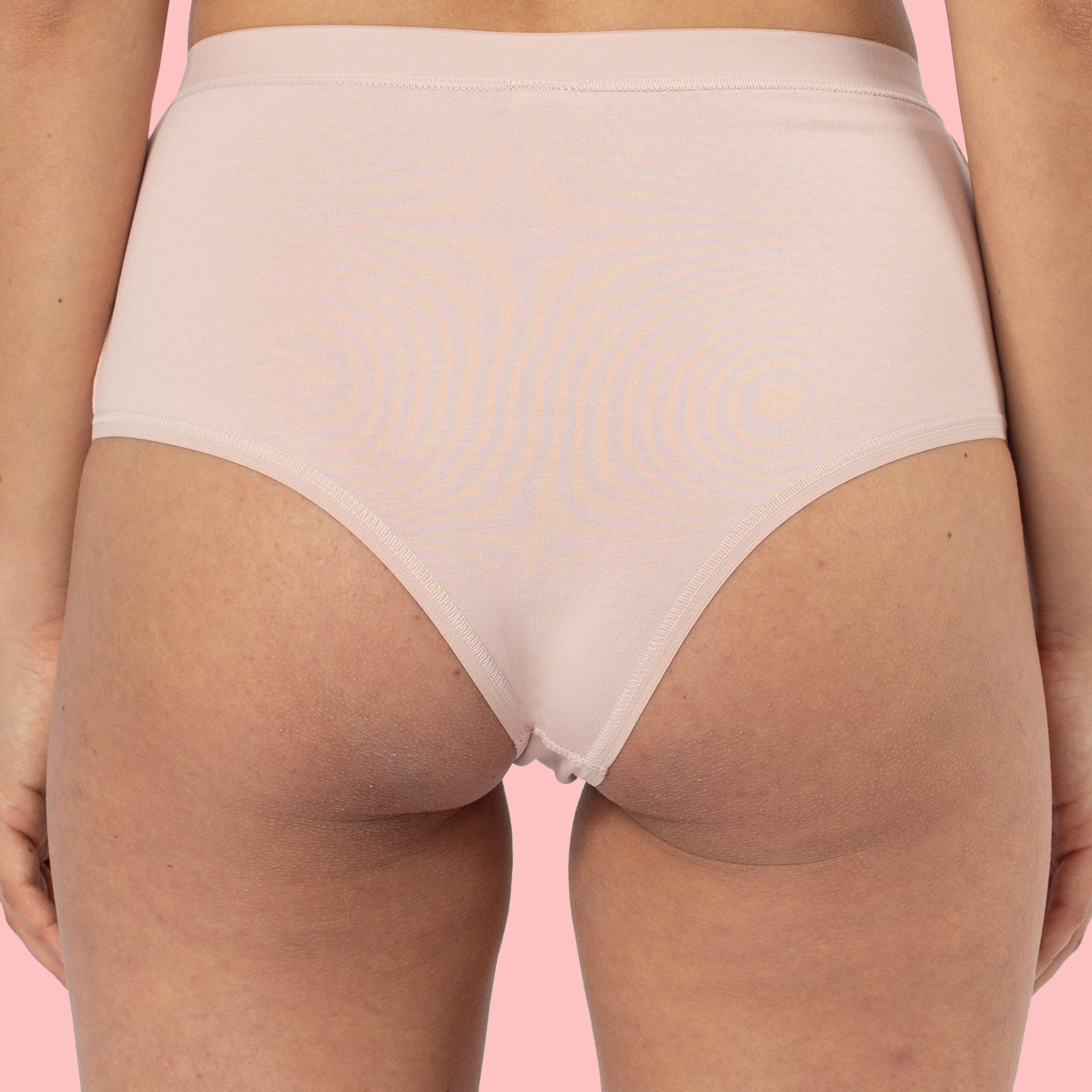 Rückansicht einer Person in einem hautfarbenen Slip vor einem rosa Hintergrund.