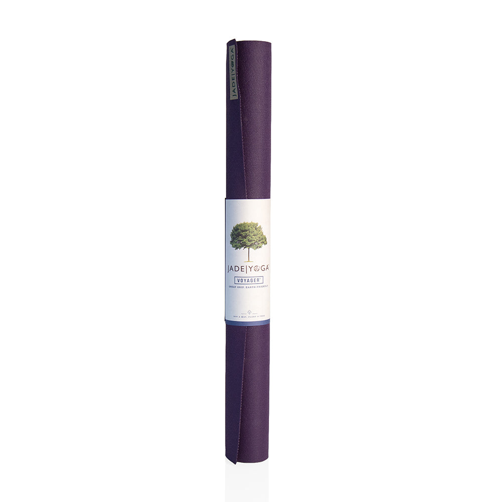 Eine aufgerollte, violette Yogamatte mit einem Etikett, das einen Baum und den Schriftzug "JADE YOGA" zeigt.